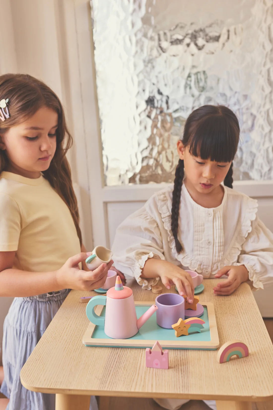 Dos niñas jugando con un juego de té de Tutete